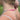 A close-up lifestyle shot of a woman outdoors wearing a delicate ombre beaded necklace with faceted crystal type beads in the front and a gold chain extender in the back,