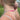 A close-up lifestyle shot of a woman outdoors wearing a delicate chain necklace with rainbow gradient beads in the front and a gold extender chain in the back.