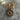 Close-up of a necklace with a gold clasp and evil eye charm on a marble surface