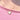 A close-up of a person wearing a delicate gold heart pendant necklace with a white Mother of Pearl inlay