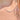 A close-up of a delicate silver necklace with a curved bar of small clear stones worn on a person's neck.