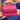 A close-up of a person holding a small, square, bright pink textured zippered case with both hands.