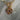 Necklace with beads and a gold multi color evil eye charm on a marble surface