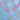A beaded necklace with pink, white, and orange striped beads, featuring a central white heart charm and small gold spacer beads, displayed on a beige and light blue checkered fabric background.